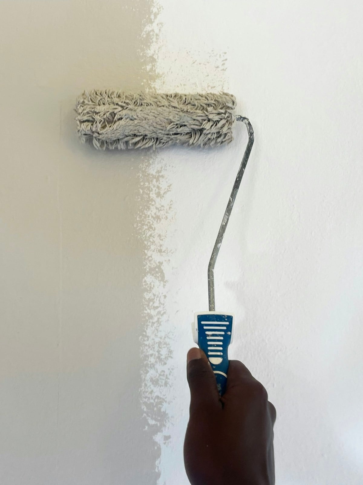 Técnico pintando una pared con rodillo
